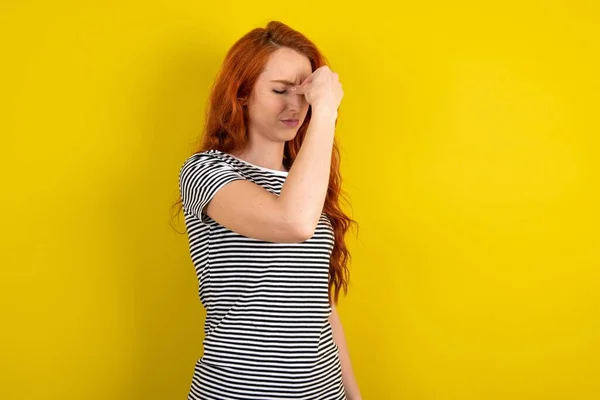 Sarı Arka Planda Çizgili Tişört Giyen Üzgün Kızıl Saçlı Kadın — Stok fotoğraf