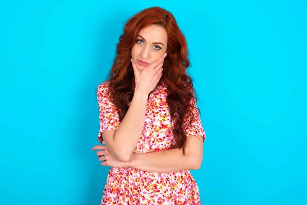 Thoughtful Smiling Young Redhead Woman Wearing Floral Dress Blue Background — Stock Photo, Image
