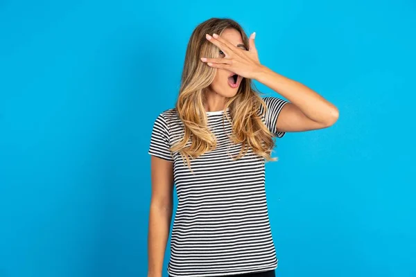 Jovem Bela Mulher Vestindo Listrado Shirt Sobre Fundo Azul Espreitando — Fotografia de Stock
