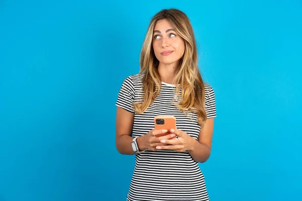 Junge Schöne Frau Trägt Gestreiftes Shirt Über Blauem Hintergrund Hält — Stockfoto