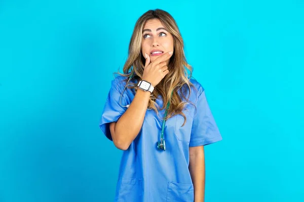 Hermosa Doctora Pie Sobre Fondo Azul Estudio Pensando Preocupado Por — Foto de Stock