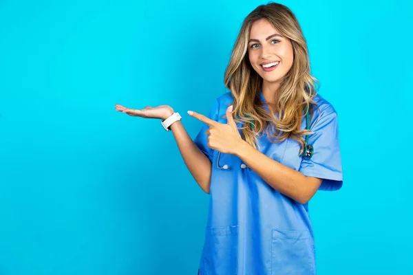 Positiv Schöne Ärztin Steht Über Blauem Studiohintergrund Promoter Zeigefinger Kopierraum — Stockfoto