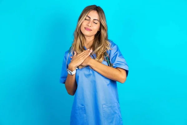 Mavi Stüdyo Arka Planında Duran Güzel Doktor Kadın Elleri Göğsünde — Stok fotoğraf