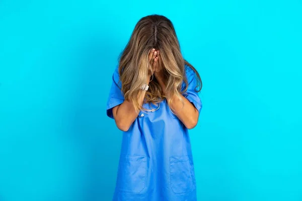 Bela Doutora Sobre Fundo Estúdio Azul Cobrindo Seu Rosto Com — Fotografia de Stock