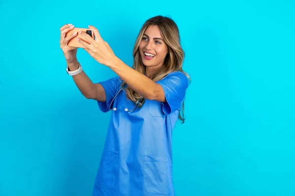 Hermosa Doctora Pie Sobre Fondo Azul Estudio Tomar Una Selfie — Foto de Stock