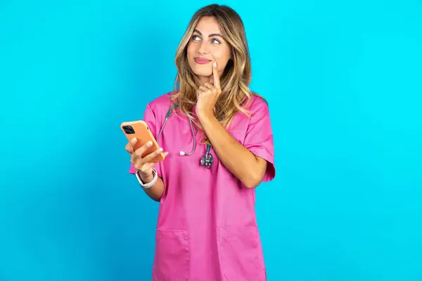 Médico Mujer Caucásica Uniforme Médico Rosa Con Estetoscopio Piensa Profundamente — Foto de Stock