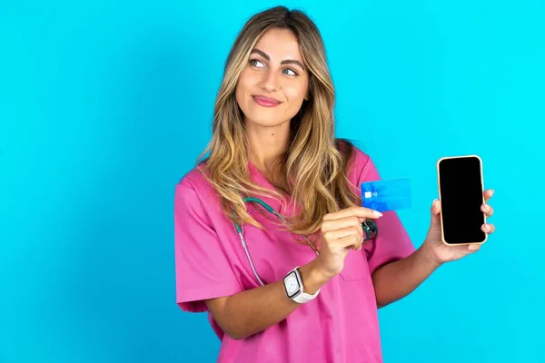 Caucasian Woman Doctor Pink Medical Uniform Stethoscope Holding Bank Card — Stockfoto