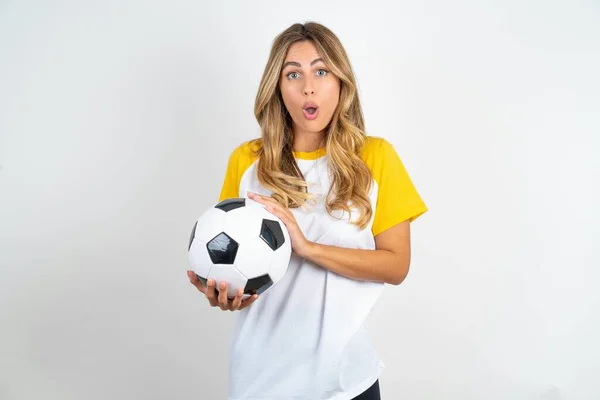 Zaskoczony Emocjonalnie Młoda Piękna Kobieta Trzyma Piłkę Nożną Białym Tle — Zdjęcie stockowe