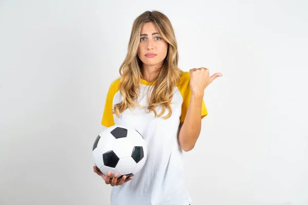 Serious Joven Hermosa Mujer Sosteniendo Pelota Fútbol Sobre Fondo Blanco —  Fotos de Stock