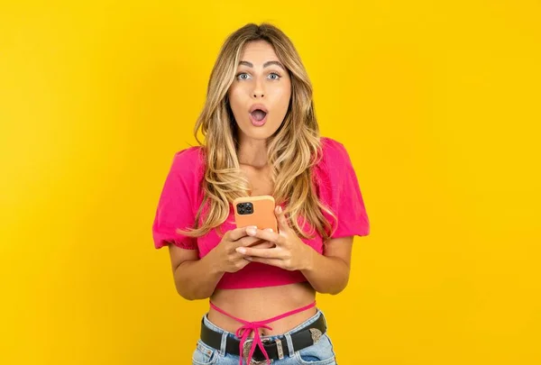 Shocked Blonde Young Woman Wearing Pink Crop Top Yellow Background — Stock Photo, Image