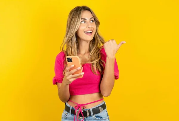 Piękna Blondynka Młoda Kobieta Różowej Bluzce Żółtym Tle Pomocą Smartfona — Zdjęcie stockowe