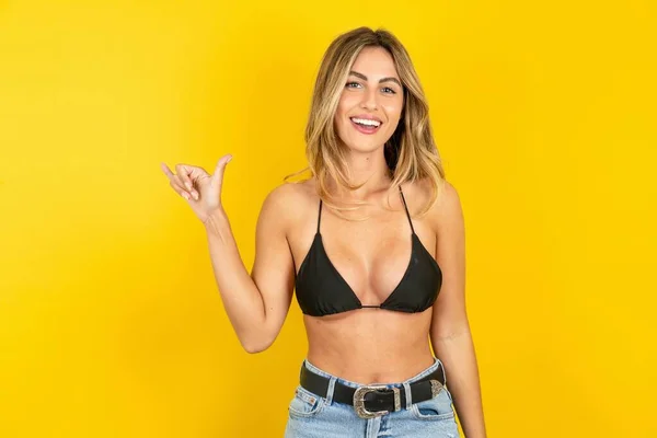 Sarı Arka Planda Bikini Giyen Güzel Sarışın Kadın Işaret Dili — Stok fotoğraf