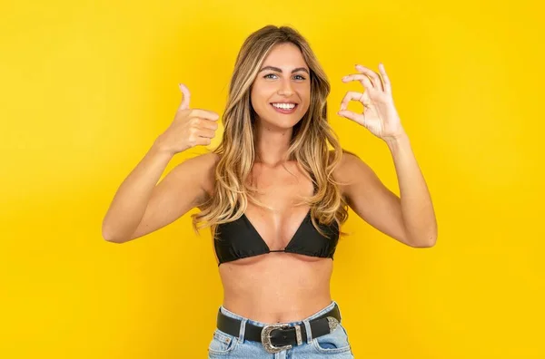 Pozitivní Mladá Blondýna Žena Nosí Bikiny Přes Žluté Pozadí Ukazující — Stock fotografie