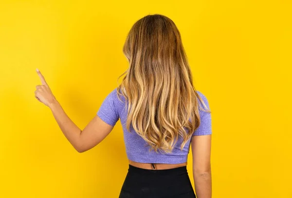 Rückansicht Einer Jungen Blonden Frau Sportbekleidung Über Gelbem Studiohintergrund Die — Stockfoto