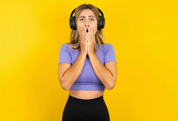 Mujer Joven Conmocionada Con Auriculares Estéreo Inalámbricos Que Usan Ropa —  Fotos de Stock
