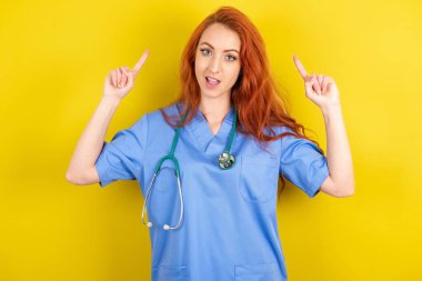 Neşeli genç kızıl saçlı doktor kadın saç modelini gösteriyor.