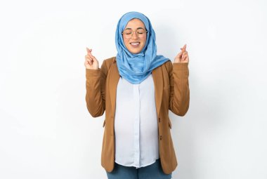 Başörtüsü takan müslüman hamile bir kadının büyük bir umudu var, şans diliyor, bol bol gülümsüyor. İnsanlar ve dilek kavramı