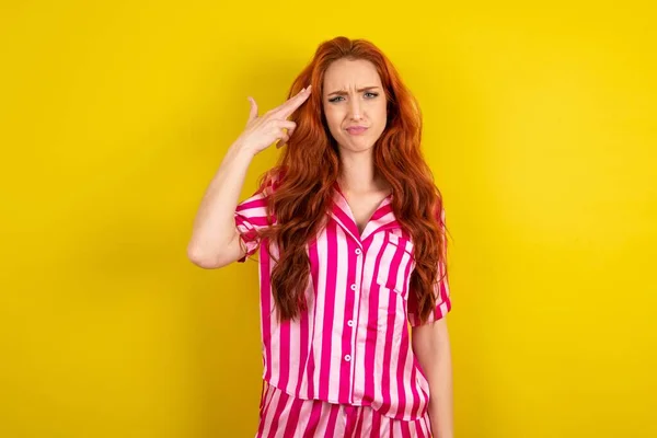Sarı Arka Planda Pembe Pijama Giyen Mutsuz Kızıl Saçlı Kadın — Stok fotoğraf