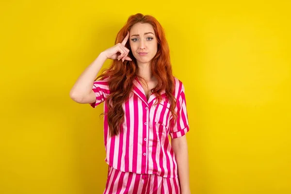 Jonge Roodharige Vrouw Draagt Roze Pyjama Gele Studio Achtergrond Probeert — Stockfoto