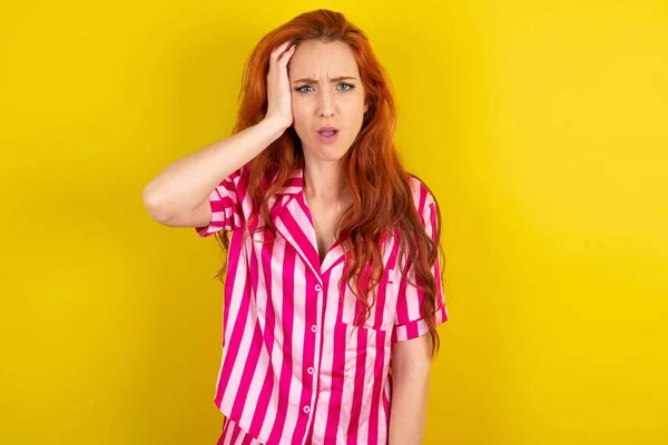 Mujer Pelirroja Avergonzada Con Pijama Rosa Sobre Fondo Estudio Amarillo — Foto de Stock