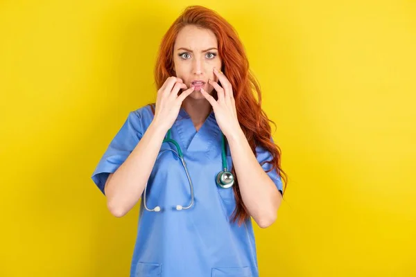 Speechless Young Red Haired Doctor Woman Keeps Hands Opened Mouth — Stock Photo, Image