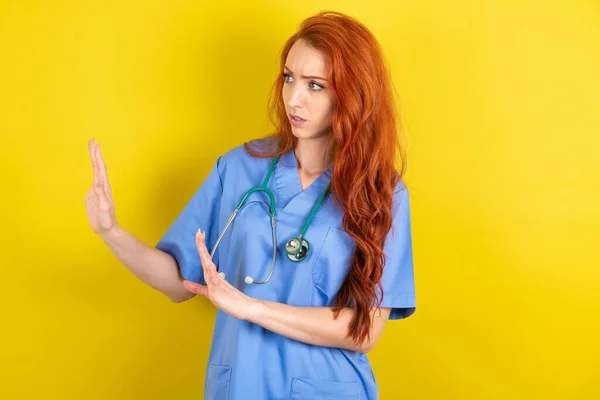 Descontente Jovem Ruiva Médico Mulher Mantém Mãos Direção Espaço Vazio — Fotografia de Stock