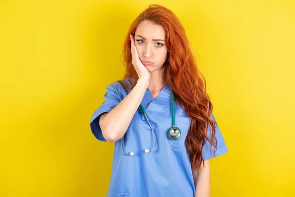 Sad Lonely Young Red Haired Doctor Woman Touches Cheek Hand — Stock Photo, Image