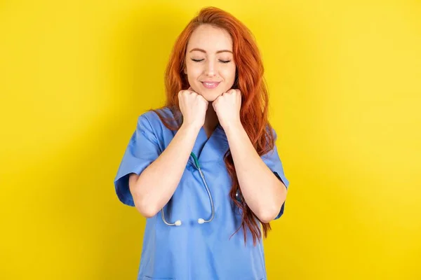 Alegre Joven Pelirroja Médico Mujer Tiene Tímido Satisfecho Expresión Sonríe —  Fotos de Stock