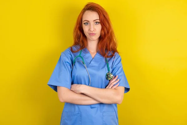 Självsäker Ung Rödhårig Läkare Kvinna Med Armarna Korsade Tittar Mot — Stockfoto
