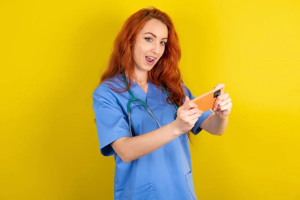 Trevlig Missbrukare Ung Rödhårig Läkare Kvinna Med Hjälp Gadget Spela — Stockfoto