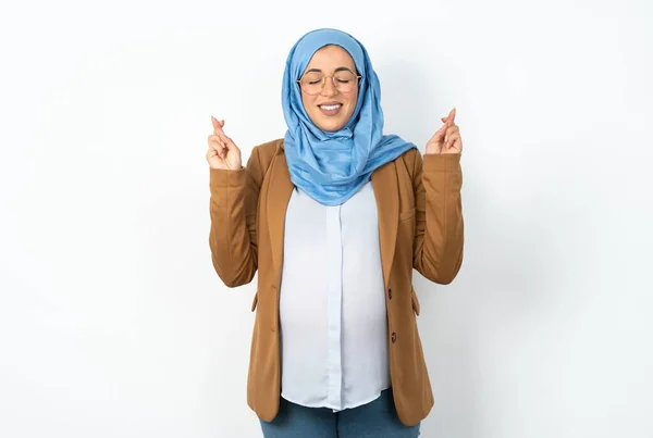ヒジャーブを着ているイスラム教徒の妊婦は大きな希望を持ち 指を交差させ 幸運を信じ 笑顔を広げています 人と願いの概念 — ストック写真