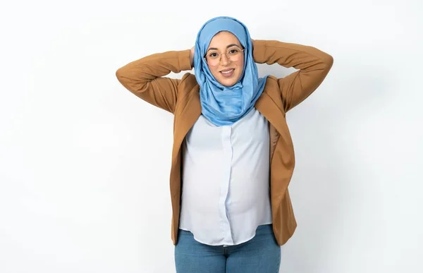 ヒジャブを着用した満足のイスラム教徒の妊婦はリラックスして頭の後ろに手を握ります — ストック写真