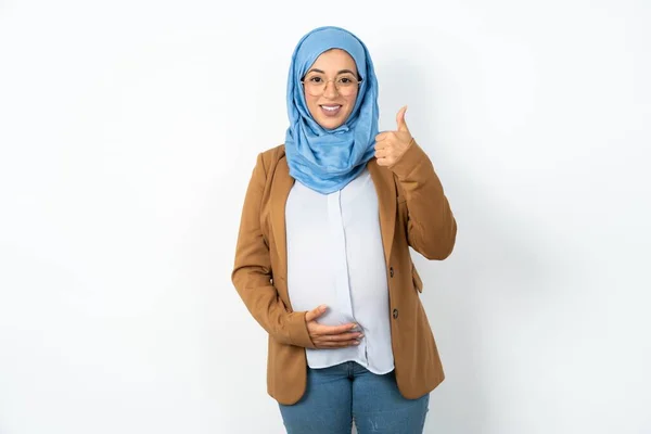 ヒジャーブを着たイスラム教徒の妊婦は ハッピーな親指で手でジェスチャーをする 成功を示すカメラを見る表現の承認 — ストック写真
