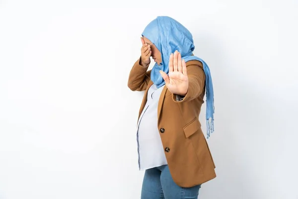 ヒジャブを着用しているイスラム教徒の妊婦は 手のひらで目を覆い ジェスチャーをやめ 誰からも隠れようとします — ストック写真