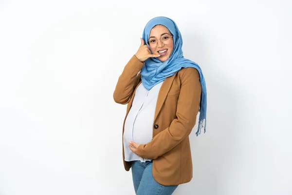 イスラム教徒の妊婦は 電話で話すような手と指で携帯電話のジェスチャーをする笑顔のヒジャブを着ています コンセプトのコミュニケーション — ストック写真