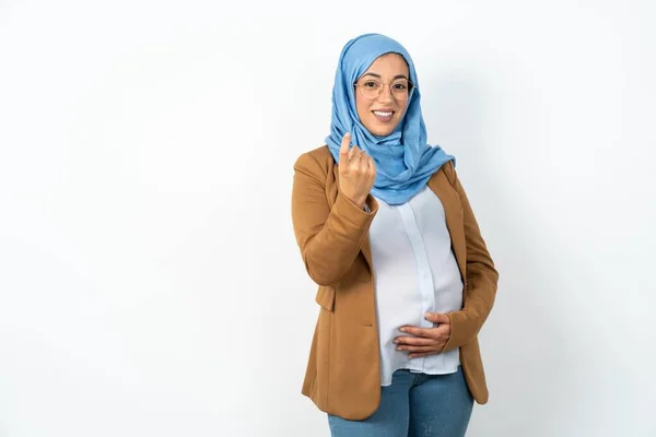 ヒジャブベッコンを着用しているイスラム教徒の妊婦は 幸せで笑顔を歓迎する手でジェスチャーに来ます — ストック写真