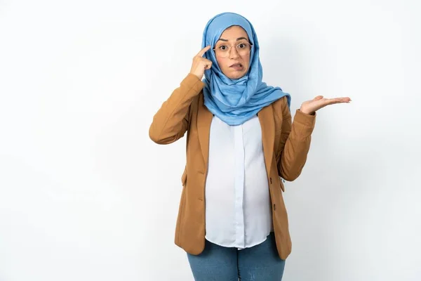 ヒジャブを着たイスラム教徒の妊婦は コピースペースを示し 額を指す開いた手のひらに困惑しました それについて考える — ストック写真