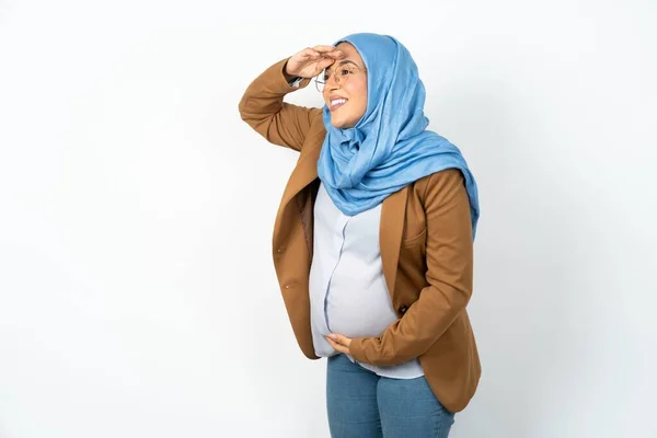 イスラム教徒の妊婦は ヒジャブを着てとても幸せで 頭の上を手で遠くに見える笑顔をしています コンセプトを検索する — ストック写真