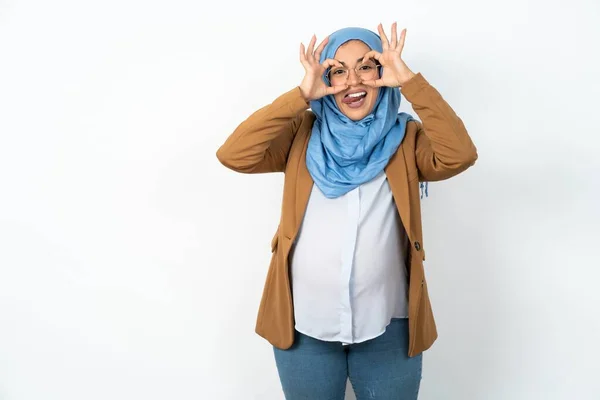 妊娠中のイスラム教徒の女性は 舌を突き刺す双眼鏡のような 良いジェスチャーをして 指を通して見ています クレイジー表現 — ストック写真