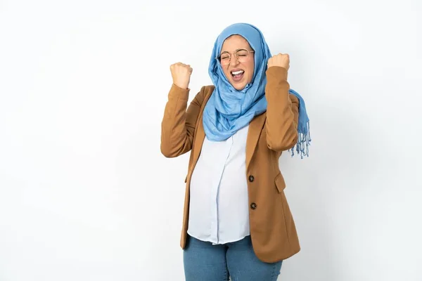 ヒジャーブを着た妊娠中のイスラム教徒の女性は 勝利を祝って腕を上げて閉じた目で成功することに興奮しています 優勝コンセプト — ストック写真