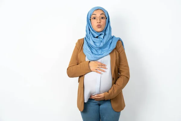 ヒジャーブを着て快適に見える美しい妊娠中のイスラム教徒の女性のショット 唇をプット カメラを見て 人間の表情 — ストック写真