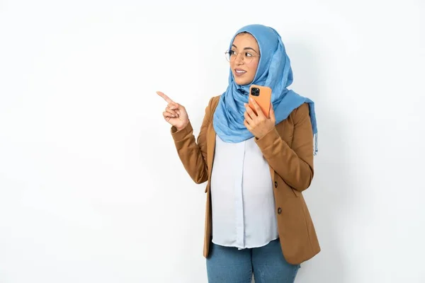 Sorrindo Mulher Muçulmana Grávida Vestindo Hijab Segurando Telefone Celular Apontando — Fotografia de Stock