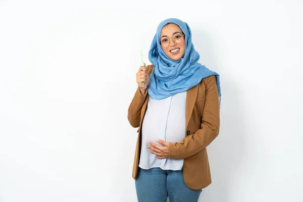 妊娠中のイスラム教徒の女性は 歯ブラシと微笑みを持ってヒジャブを着用しています 歯科医療コンセプト — ストック写真