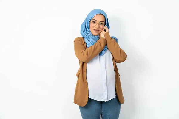 ヒジャブを着用している美しい妊娠中のイスラム教徒の女性を魅了し カメラで優しく顔の笑顔の近くに手を保ちます — ストック写真