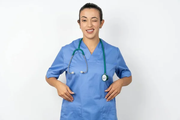 Kokieteryjna Arabska Lekarka Niebieskim Mundurze Uśmiechnięta Szczęśliwie Mrugająca Przed Kamerą — Zdjęcie stockowe