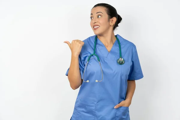 Charmoso Árabe Médico Mulher Vestindo Uniforme Azul Olhando Para Espaço — Fotografia de Stock