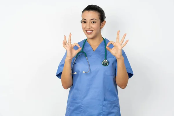 Okサインで両手を指で示す青い制服を着ているアラブの医師の女性 承認または推奨コンセプト — ストック写真