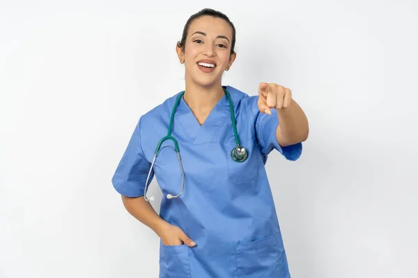 アラブの医師の女性は 満足して 自信を持って フレンドリーな笑顔でカメラを指す青い制服を着て あなたを選択します — ストック写真