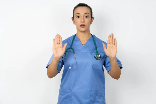 Poważna Arabska Lekarka Niebieskim Mundurze Ciągnie Dłonie Kamery Robi Gest — Zdjęcie stockowe