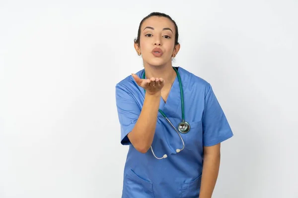 Arabski Lekarz Kobieta Noszenie Niebieski Mundur Patrząc Aparat Dmuchanie Pocałunek — Zdjęcie stockowe